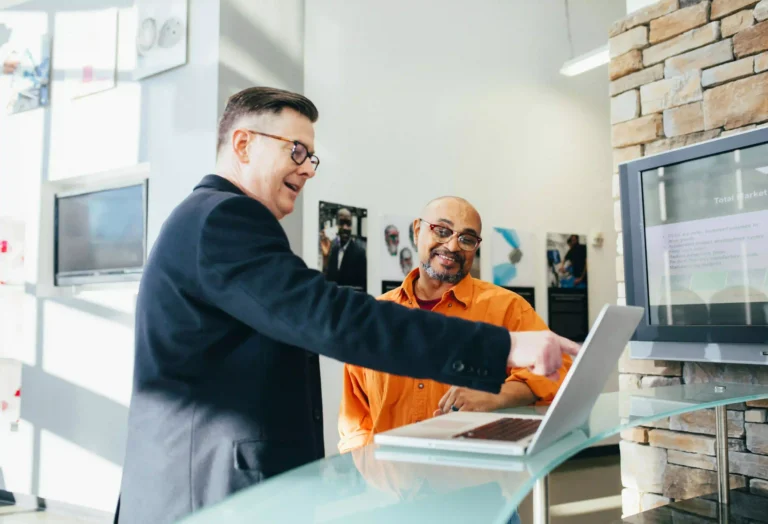 man teaching another man computer