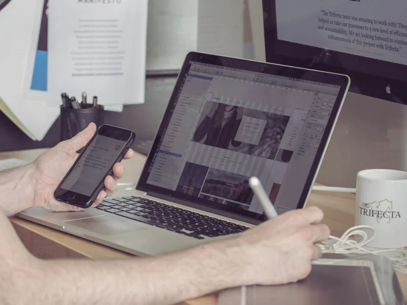 business site on phone laptop and desktop person taking notes